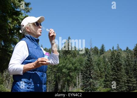 Senioren blowing bubbles Stockfoto