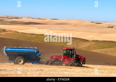 Schlepper ziehen einen Korn-Karren durchquert ein Feld bei der Ernte in der Palouse Region Washington Stockfoto