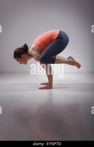 Schön sportlich fit Yogini Frau Praktiken Yoga Asana kakasana Stockfoto