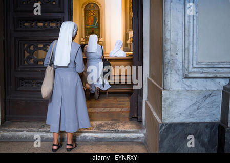 Nonnen beten Rom, hält eine Nonne an der Schwelle einer Kapelle in der Basilica di San Giovanni in Laterano in Rom bevor er anderen Nonnen an Gebet. Stockfoto