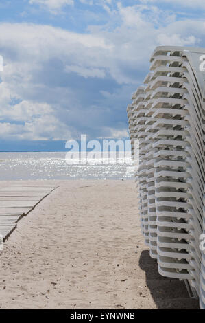 Sonnenliegen am Strand bei stürmischem Wetter gestapelt Stockfoto