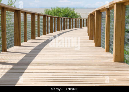 Holzbrett Weg mit Sicherheitszaun führt an der Küste Stockfoto