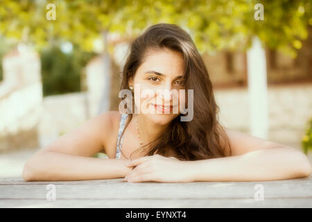 Schöne junge Frau lächelnd auf Garten Stockfoto