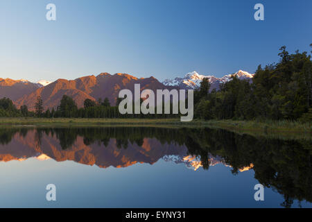 Twin Peaks zu reflektieren, in der schönen Lake Matheson bei Sonnenuntergang, Südalpen, Südinsel, Neuseeland Stockfoto