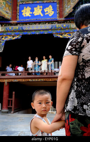 Ankang, chinesischen Provinz Shaanxi. 2. August 2015. Ein Junge und seine Großmutter hören Sie eine Probe der Oper in Shuhe Stadt, Xunyang County, im Nordwesten der chinesischen Provinz Shaanxi, 2. August 2015. 53 km östlich von Xunyang County gelegene war Shuhe die antike Stadt einst ein berühmter Hafen in der maritimen Geschichte Chinas. Die Stadt unterstreicht Gassen voller Geschäfte und Verkäufer steht. Besucher könnten berühren die Steinwände des tausend Jahre alten Burgen und genießen Sie die Schönheit der alten Gebäude. Bildnachweis: Tao Ming/Xinhua/Alamy Live-Nachrichten Stockfoto