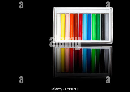 zwölf Ölkreide auf einem schwarzen Hintergrund mit Reflexion Stockfoto