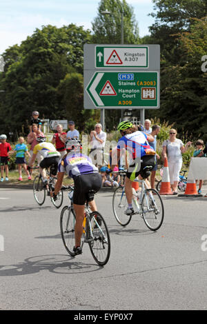 Esher, Surrey, England, UK. 2. August 2015. Teilnahme an der aufsichtsrechtlichen RideLondon-Surrey 100 Amateur-Radfahrer. Die 100-Meilen-Herausforderung ist auf der gleichen Strecke wie die Profis mit den zusätzlichen Anreiz von Geld für wohltätige Zwecke zu sammeln. Eine Gruppe von Radfahrern übergeben die Unterstützung von öffentlichen Kreisverkehr die Scilly-Inseln entlang der Portsmouth-Straße in Richtung Kingston am Bein der Fahrt heimwärts. Stockfoto