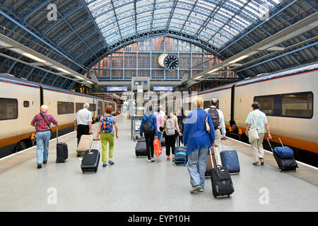 Eurostar-Zug St Pancras internationaler Eurostar-Bahnsteig Rückansicht Gruppe von Passagieren, die Koffer zum Bahnhofsausgang in Camden London, England, Großbritannien, schleppen Stockfoto