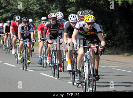 Esher, Surrey, England, UK. 2. August 2015. Teilnahme an der aufsichtsrechtlichen RideLondon-Surrey 100 Amateur-Radfahrer. Die 100-Meilen-Herausforderung ist auf der gleichen Strecke wie die Profis mit den zusätzlichen Anreiz von Geld für wohltätige Zwecke zu sammeln. Eine Gruppe von Radfahrern verlaufen entlang der Portsmouth Road in Richtung Kingston am Bein der Fahrt heimwärts. Stockfoto