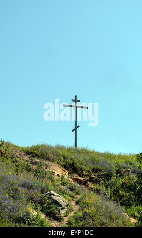 Große alte hölzerne orthodoxe Kreuz auf einem Hügel an einem klaren, blauen wolkenlosen Himmel an einem Sommertag Stockfoto