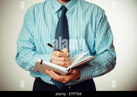 Büropersonal schreibt Notizen im Tagebuch-Bericht Stockfoto