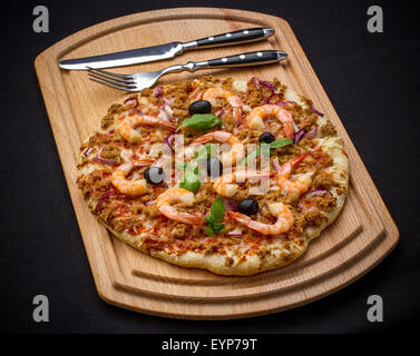 Thunfisch-Pizza mit Garnelen und Besteck, Ansicht von oben Stockfoto