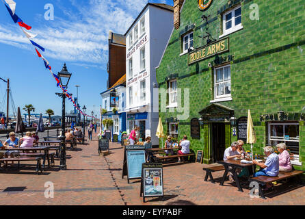 Menschen sitzen vor den Poole Arms Pub auf The Quay in Poole, Dorset, England, UK Stockfoto