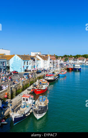 Leute sitzen außen Pubs und Bars auf Custom House Quay in Weymouth, Jurassic Coast, Dorset, England, UK Stockfoto