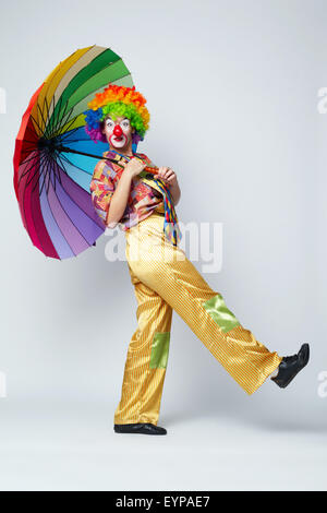 Clown mit bunten Regenschirm auf weiß Stockfoto