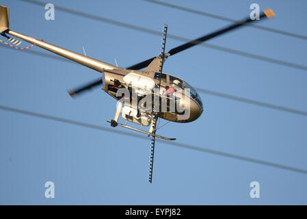 Greymouth, Neuseeland, 22. Juni 2015: Ein nicht identifizierter Hubschrauber-Pilot vermeidet Stromkabel während des Sprühens Dünger Stockfoto