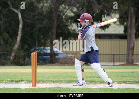 Einen jungen Cricket-Spieler nach den Ball bei einem Nachwuchsspiel Cricket in einem Vorort von Adelaide, South Australia Stockfoto