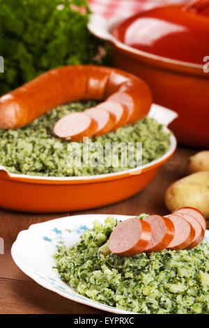 Einem rustikalen Tisch mit einer Platte mit "trafen sich Boerenkool schlimmsten Fall" oder Grünkohl mit geräucherter Wurst, traditionelle niederländische Gerichte. Stockfoto