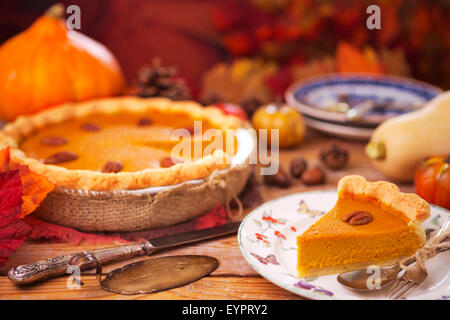 Hausgemachte Kürbis-Kuchen auf einem rustikalen Tisch mit herbstlichen Dekorationen. Stockfoto