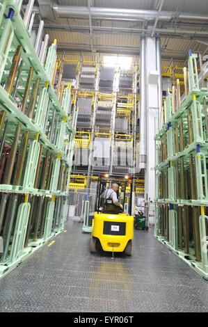 In einer modernen Automobilfabrik bewegen Fahrzeuge und Ersatzteile durch den Produktionsprozess, Gabel-LKW im Lager Stockfoto