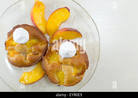 Dekoriert mit Sahne und frischen Pfirsich Scheiben auf dem Silbertablett serviert hausgemachte Obst-muffins Stockfoto