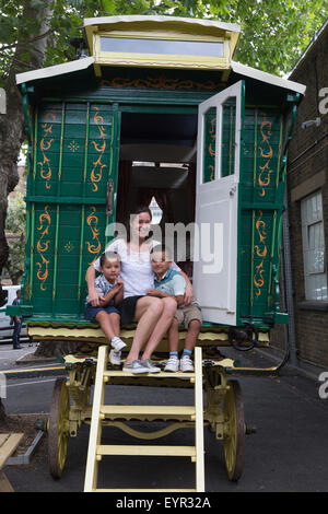 London, UK. 3. August 2015. Sophie Wiles sitzt mit ihren Söhnen Noah und Joshua in einem dekorierten "Burton" Wohnwagen, ca. 1920, renoviert 2015, 25.000-35 000 GBP zu schätzen. Am 10. September 2015 Christie's South Kensington halten die dritte jährliche "außergewöhnliches" zu versteigern, feiern alle Dinge außergewöhnliche und ungewöhnlich - aus einer massiven T-Rex, ein Porträt von Barack Obama aus Spielzeug. Die Vorschau markiert den Beginn einer kostenlos fünf-Wochen-Sommer-Ausstellung, Eröffnung für die Öffentlichkeit am 3. August 2015. Foto: Ukartpics/Alamy Live-Nachrichten Stockfoto