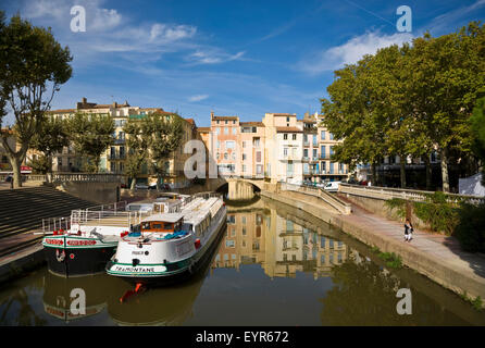 Lastkähne auf dem Canal du Midi, wie es unter der 1. Jahrhundert Pont de Marchands bewohnte Brücke in Narbonne, Languedoc-Roussillon, Frankreich läuft Stockfoto