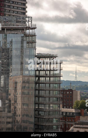 London, England. Reflexion in einem modernen Gebäude im Bau mit dem Kristallpalast Fernsehturm Sender. Stockfoto