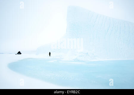 Inuit-Führer sammeln Eis für Trinkwasser aus Eisberg eingefroren im Meer Eis, Scholle Rand, Baffin Bay, Nunavut, Kanada. Stockfoto