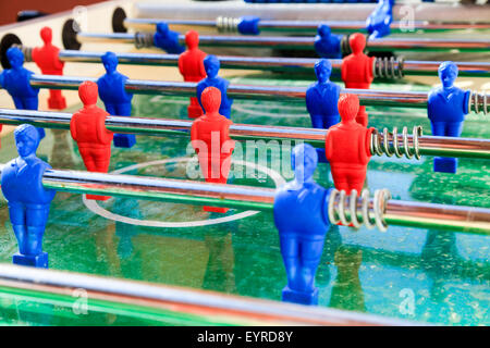 Blaue und rote Spieler auf einem Tischfußball-Tisch Stockfoto
