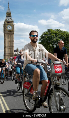 London zu fahren. Radfahrer Nutzen des Verkehrs freie Straßen und radeln vorbei an Parlament Stockfoto