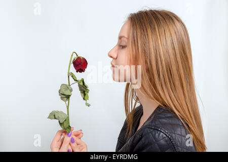 traurige Frau mit getrockneten Rose auf weißem Hintergrund Stockfoto