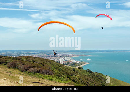 Gleitschirme fliegen über Beachy Head mit Eastbourne und Eastbourne Pier im Hintergrund, Eastbourne, East Sussex, UK Stockfoto