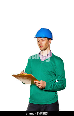 Junge Architekten, einen Helm zu tragen. Bauarbeiter, Notizen in der Checkliste. Der Mann konzentriert sich auf den Job. Stockfoto