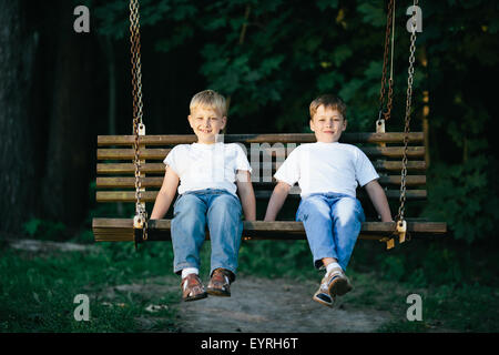 kleine Jungs träumen auf Schaukel Stockfoto