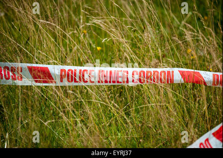 Rural England. Roten und weißen Polizei-Band in einem Feld. Stockfoto