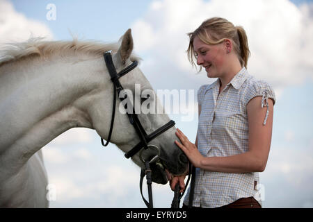 Eine junge Frau streicheln ein Grauschimmel Connemara Stockfoto