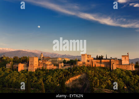 Mond und goldenen Sonnenuntergang auf Hügel Festung Alhambra Palast Komplex Granada Spanien mit Schnee bedeckt Sierra-Nevada-Berge Stockfoto