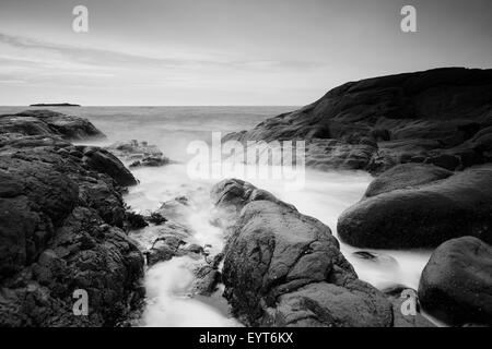 Wellen zwischen Felsen an der Küste, s/w, Stockfoto