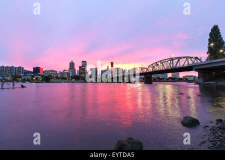 Rosa Sonnenuntergang über der Skyline von Portland Oregon Innenstadt am Wasser entlang Willamette River von Hawthorne Bridge Stockfoto