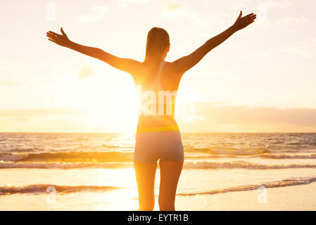 Glücklich erfolgreichen Fitness-Frau heben die Arme zum Himmel bei Sonnenuntergang. Erfolg, Ziele und Erfolg zu feiern. Gesund aktiv Lif Stockfoto