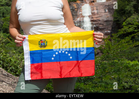 Die venezolanische Fahne in den Händen von Frau mit den Angel Fall im Hintergrund, Venezuela 2015. Stockfoto