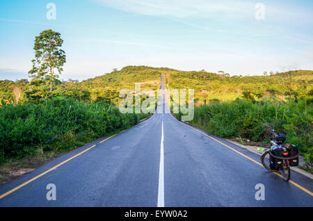 Brandneue Teerstraße in Angola und ein Tourenrad in den Dembos Hügeln in der Nähe von Quibaxe Stockfoto