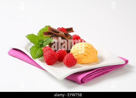 Mini-Schokoladen-Kuchen mit frischen Himbeeren und Kugel Eis serviert Stockfoto