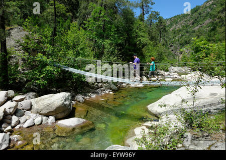 Wanderer auf einer Hängebrücke über den Fluss Bonifatu am Weitwanderweg Tra Mare e Monti und GR20 Stockfoto