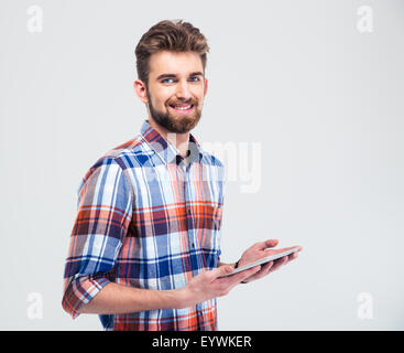 Porträt von einem lächelnden Mann hält Tablet-Computer und Blick in die Kamera auf einem weißen Hintergrund isoliert Stockfoto