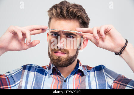 Mann, Blick in die Kamera unter Dollarschein isoliert auf weißem Hintergrund Stockfoto