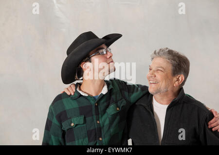 Junger Mann mit Autismus und seinem Mentor einander betrachtend und lächelnd Stockfoto