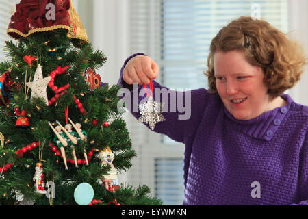 Junge Frau mit Autismus Weihnachtsbaum Ornament aufsetzen Stockfoto