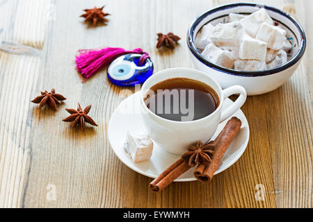 Tasse Kaffee mit Gewürzen und türkische Süßigkeiten und Glas Amulett Evil Eye Stockfoto